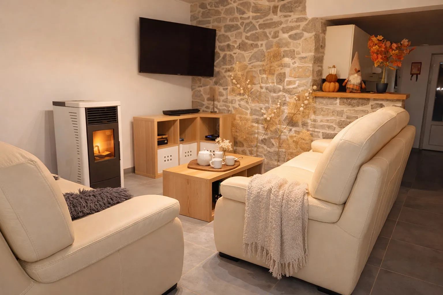 Salon chaleureux avec mur en pierre et poêle à pellets du gîte à Cerfontaine